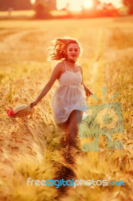 Happy Young Blonde Girl In White Dress With Straw Hat Running Th… Stock Photo