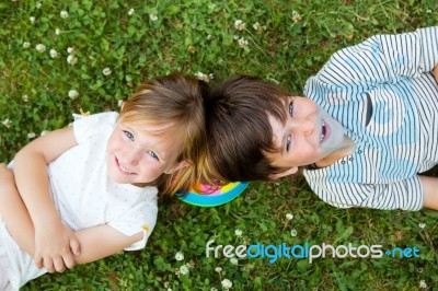 Happy Young Brothers Lying On Grass Stock Photo