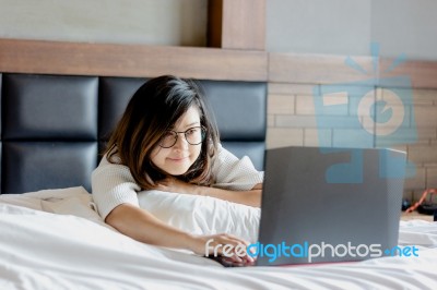 Happy Young Businesswoman Wear Glasses Working On Laptop In Bedr… Stock Photo
