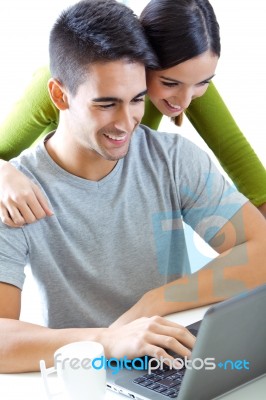 Happy Young Couple Browsing Internet At Home Stock Photo