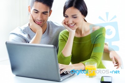 Happy Young Couple Browsing Internet At Home Stock Photo