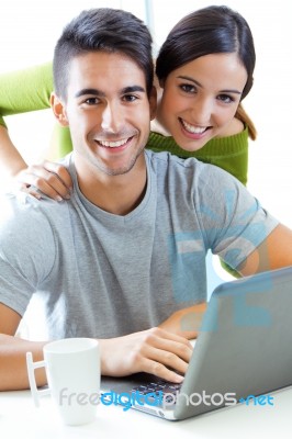 Happy Young Couple Browsing Internet At Home Stock Photo