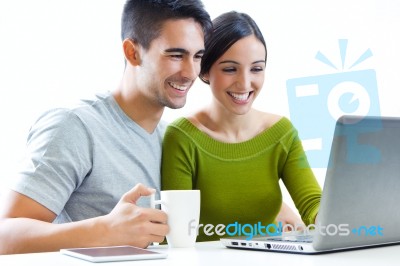 Happy Young Couple Browsing Internet At Home Stock Photo