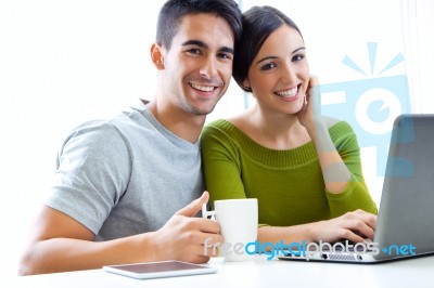 Happy Young Couple Browsing Internet At Home Stock Photo