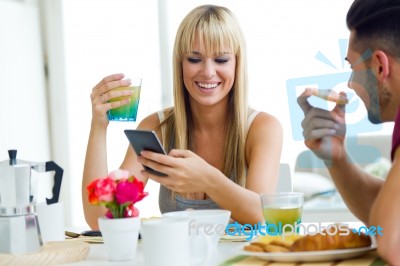 Happy Young Couple Enjoying Breakfast In The Kitchen Stock Photo