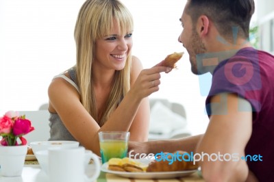 Happy Young Couple Enjoying Breakfast In The Kitchen Stock Photo