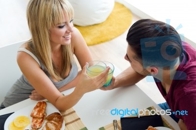 Happy Young Couple Enjoying Breakfast In The Kitchen Stock Photo