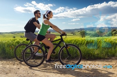 Happy Young  Couple On A Bike Ride In The Countryside Stock Photo