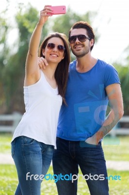 Happy Young Couple Taking Selfies With Her Smartphone In The Par… Stock Photo