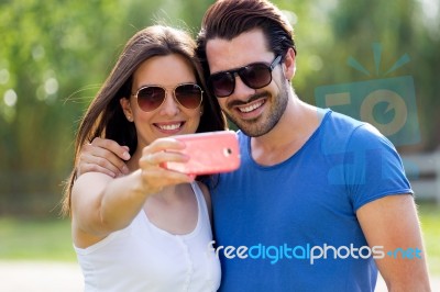 Happy Young Couple Taking Selfies With Her Smartphone In The Par… Stock Photo