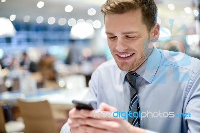 Happy Young Executive Using Smart Phone Stock Photo