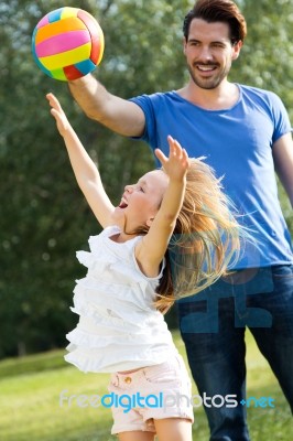 Happy Young Family, Father And Son Playing Ball In The Park Stock Photo