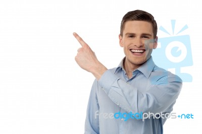 Happy Young Man Pointing At Something Stock Photo