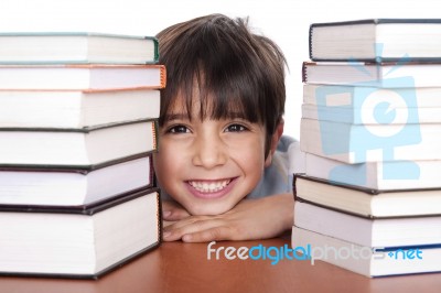 Happy Young School Boy Surrounded By Books Stock Photo