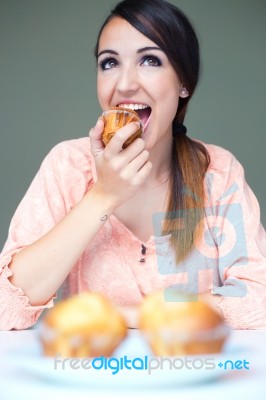 Happy Young Woman Eating Delicious Muffins Stock Photo