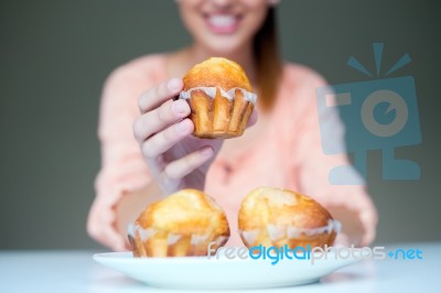 Happy Young Woman Eating Delicious Muffins Stock Photo