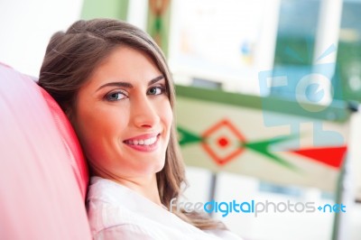 Happy Young Woman Relaxing On Sofa Stock Photo