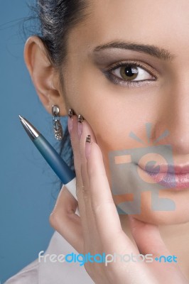 Happy Young Woman With A Pen In Hand Over Blue Background Stock Photo