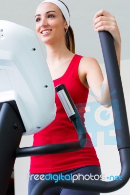 Happy Young Woman  With Elliptic Machine In The Gym Stock Photo