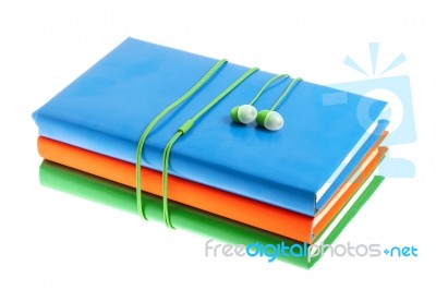 Headphones And Stack Of Multicolored Books On A White Background… Stock Photo