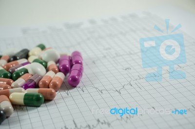 Heap Of Medicine Pills On Cardiogram Grid Paper. Selective Focus… Stock Photo