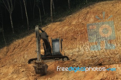 Heavy Road Construction Machine Working On Hill Slope Stock Photo