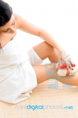 High Angle View Of Woman Scrubbing Her Legs On White Background Stock Photo