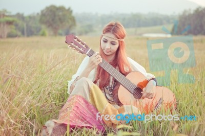 Hippie Girl Playing Guitar On Grass Stock Photo