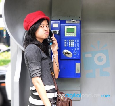 Hispanic Woman Talking In A Public Phone Stock Photo