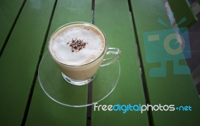 Hot Cappuccino Coffee In Glass Mug On Green Table Stock Photo