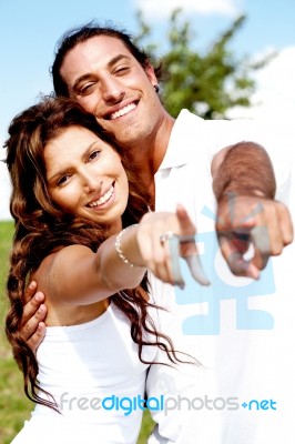 Hugging Couple Pointing Far Stock Photo