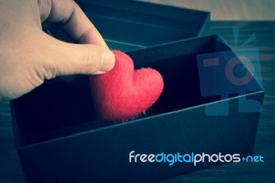 Human Hand Holding Or Putting A Red Heart-shaped In A Black Gift… Stock Photo