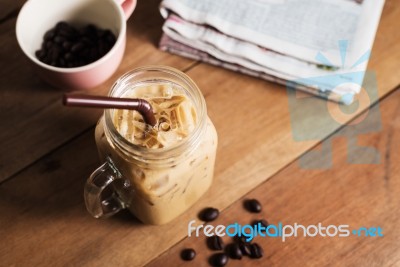 Ice Coffee With Milk And Newspaper On Table Stock Photo