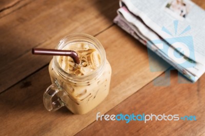 Ice Coffee With Milk And Newspaper On Table Stock Photo