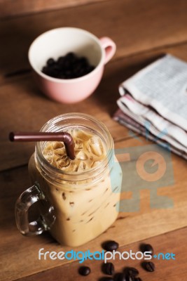 Ice Coffee With Milk And Newspaper On Table Stock Photo