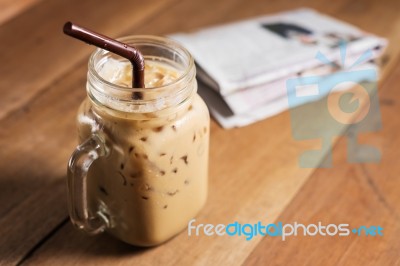 Ice Coffee With Milk And Newspaper On Table Stock Photo