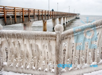 Ice Covered Fence On The Beach Stock Photo