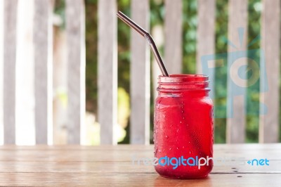 Iced Drink In Red Glass On Wooden Table Stock Photo