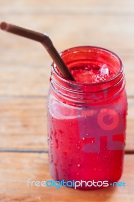 Iced Drink In Red Glass On Wooden Table Stock Photo