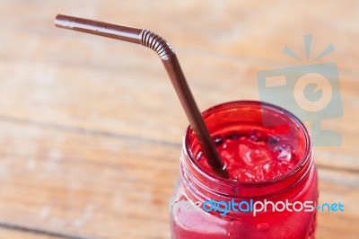 Iced Drink In Red Glass On Wooden Table Stock Photo