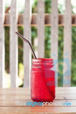 Iced Drink In Red Glass On Wooden Table Stock Photo