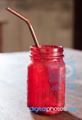 Iced Drink In Red Glass On Wooden Table Stock Photo