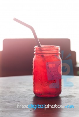 Iced Drink In Red Glass On Wooden Table Stock Photo