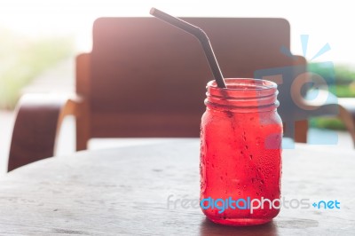 Iced Drink In Red Glass On Wooden Table Stock Photo