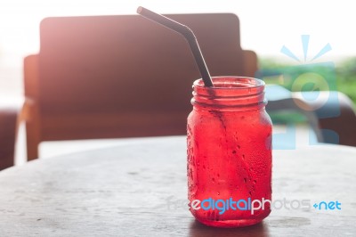 Iced Drink In Red Glass On Wooden Table Stock Photo