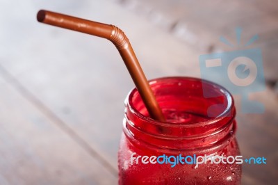 Iced Drink In Red Glass On Wooden Table Stock Photo