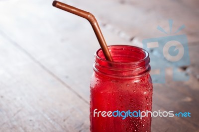 Iced Drink In Red Glass On Wooden Table Stock Photo