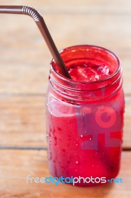 Iced Drink In Red Glass On Wooden Table Stock Photo