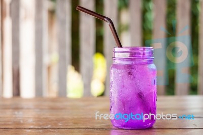 Iced Drink In Violet Glass In Coffee Shop Stock Photo