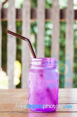 Iced Drink In Violet Glass In Coffee Shop Stock Photo